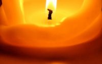 A large lit candle with wax folding inward