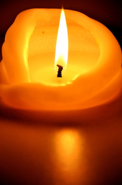 A large lit candle with wax folding inward