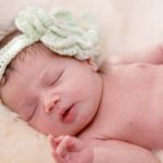 baby girl with mint green crocheted floral band sleeping