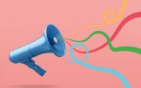 Stock graphic of a metallic blue bullhorn with bright curly ribbons of color coming out against a plain salmon background. No text.